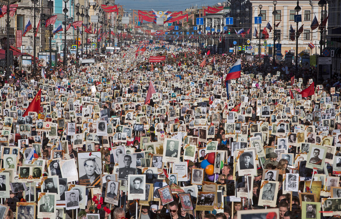  In this photo dated Saturday, May 9, 2015, local residents carry portraits of their ancestors, participants in World War Two as they celebrate the 70th anniversary of the defeat of the Nazis in World War II in St. Petersburg, Russia. About 100,000 p