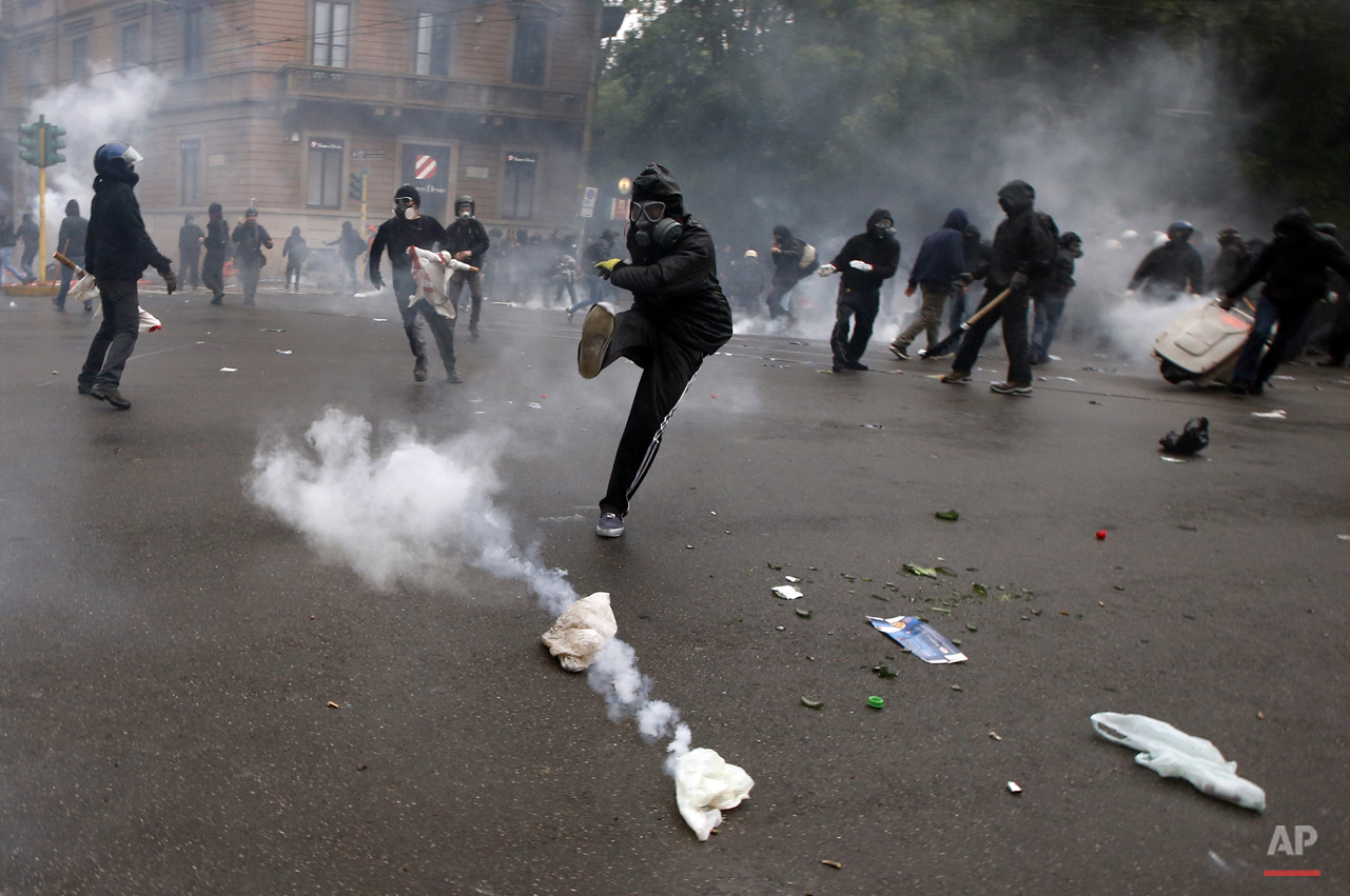  A demonstrators kicks a teargas canister as clashes broke out with  Italian Policemen during a protest against the Expo 2015 fair in Milan, Italy, Friday, May 1, 2015. (AP Photo/Luca Bruno) 