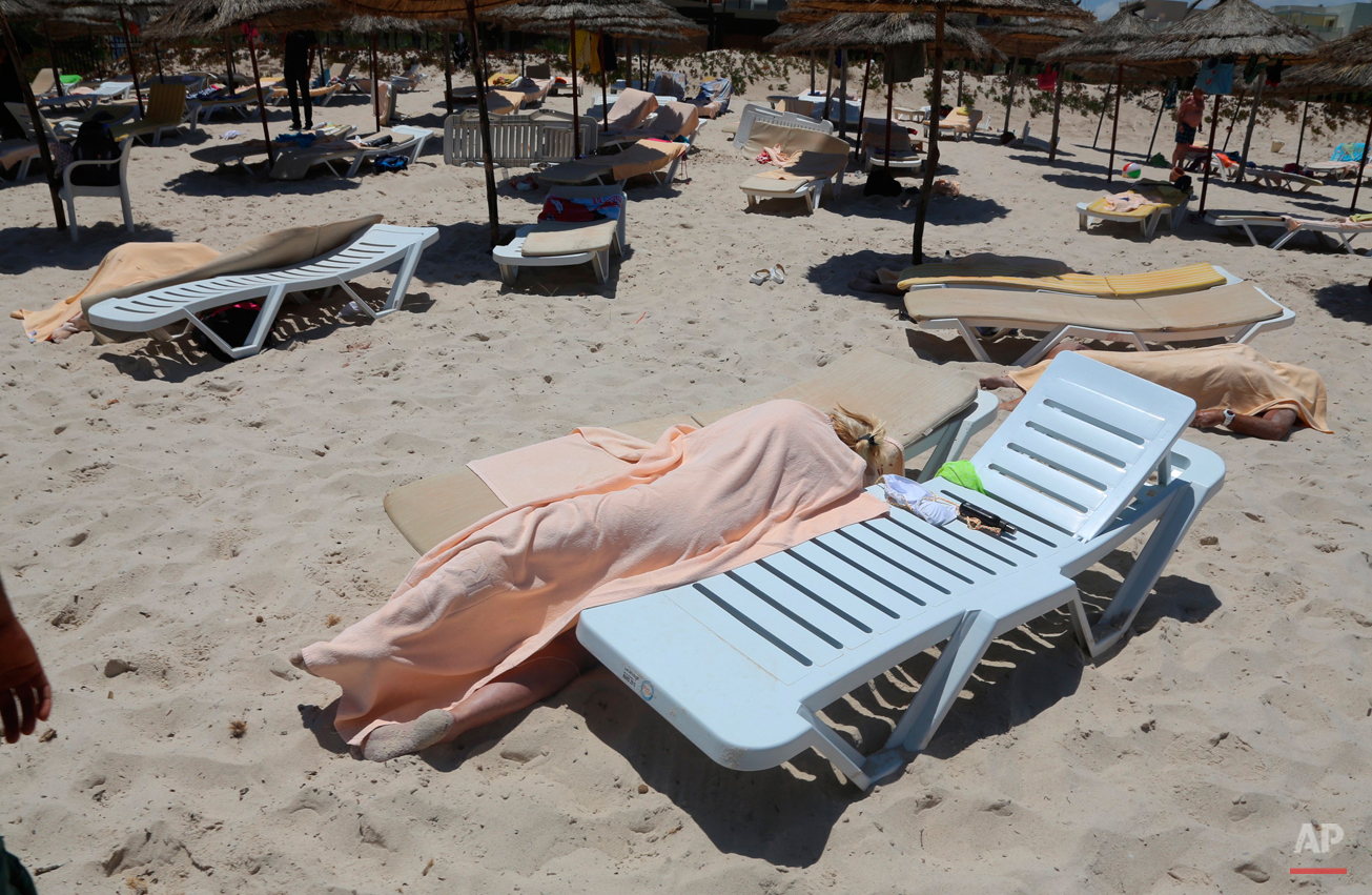  Bodies are covered on a Tunisian beach, in Sousse, Friday June 26, 2015. A man unfurled an umbrella and pulled out a Kalashnikov, opening fire on European sunbathers in an attack that killed at least 28 people at the beach resort in one of three dea