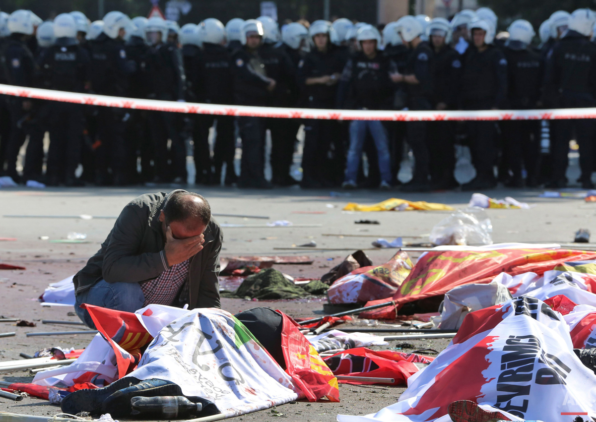  A man cries over the body of a victim at the site of an explosion in the capital Ankara, Turkey, Saturday, Oct. 10, 2015. Two bomb explosions targeting a peace rally killed dozens of people and injured scores of others near Ankara's main train stati