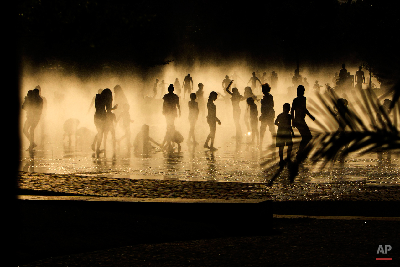  People cool down in a fountain beside Manzanares river in Madrid, Spain, Tuesday, June 30, 2015. Weather stations across Spain are warning people to take extra precautions as a heat wave engulfs much of the country, increasing the risk of wildfires.