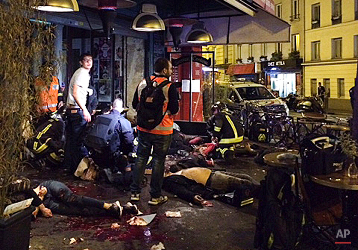  Victims of a shooting attack lie on the pavement outside La Belle Equipe restaurant in Paris Friday, Nov. 13, 2015.   (Anne Sophie Chaisemartin via AP) 