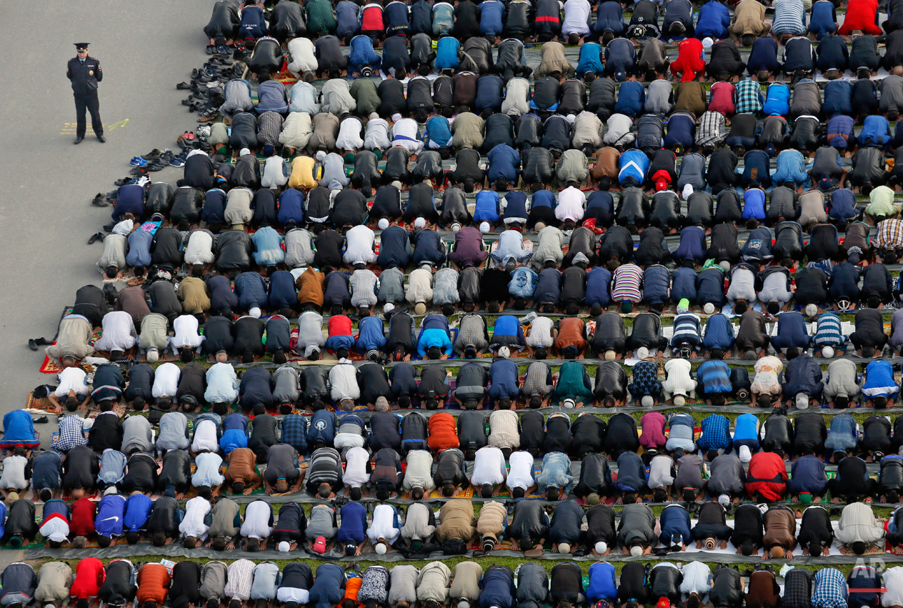  A policeman stands guard as Muslims take part in Eid al-Fitr prayers at a mosque in St. Petersburg, Russia, Friday, July 17, 2015. Millions of Muslims across the world are celebrating the Eid al-Fitr holiday, which marks the end of the month-long fa