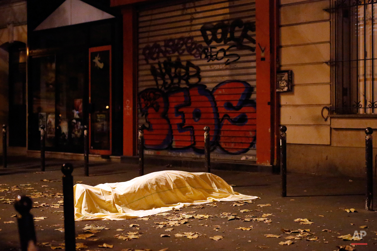  A victim of a terrorist attack lies dead outside the Bataclan theater in Paris, Nov. 13, 2015. The Islamic State group claimed responsibility for Friday's attacks on a stadium, a concert hall and Paris cafes that left more than 120 people dead and o