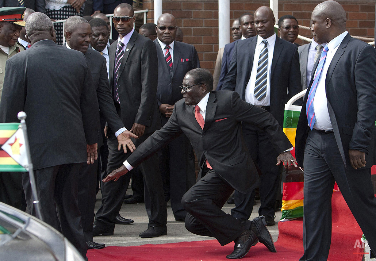  Zimbabwean President Robert Mugabe, center, falls after addressing supporters upon his return from an African Union meeting in Ethiopia, Wednesday, Feb. 4, 2015. Mugabe, 90, was elected chairman of the African Union and is set to celebrate his 91st 