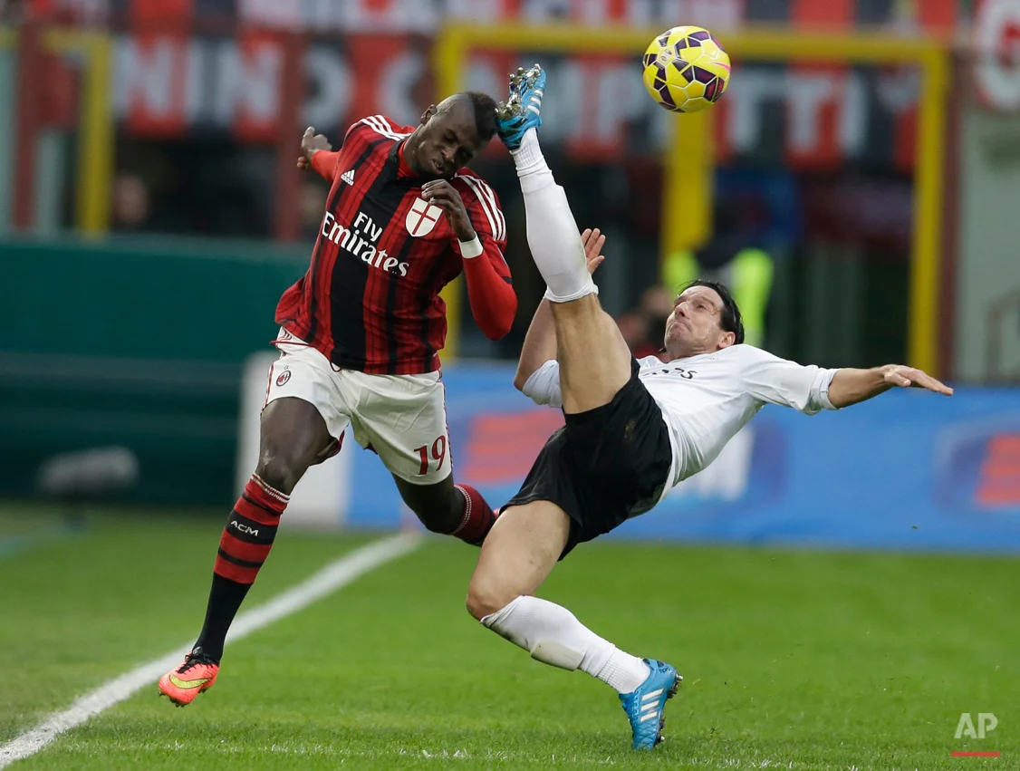 In this Jan. 18, 2015 photo, AC Milan's Mbaye Niang, left, challenges for the ball with Atalanta's Giuseppe Biava during a Serie A soccer match between AC Milan and Atalanta, at the San Siro stadium in Milan. (AP Photo/Luca Bruno)