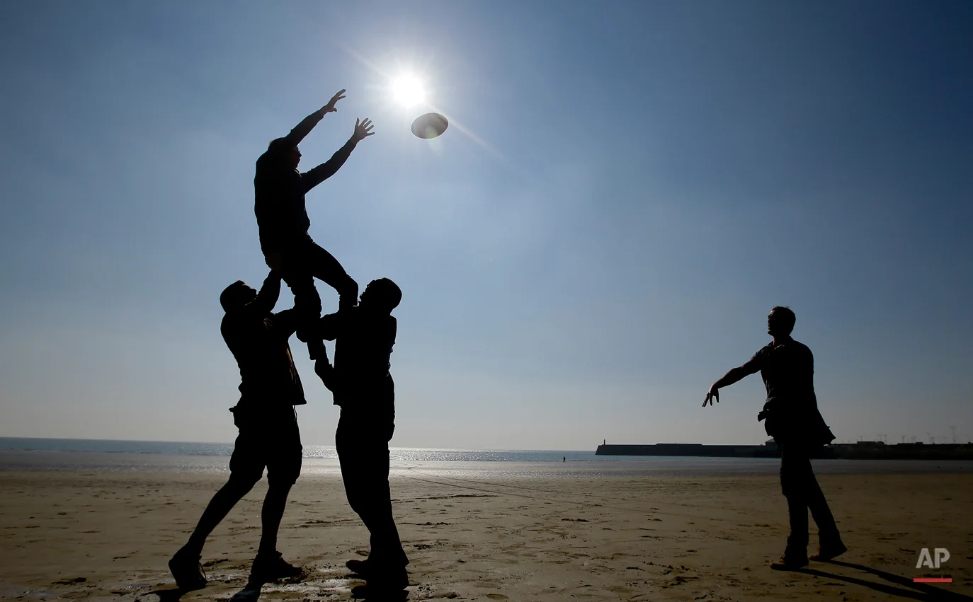 In this Oct. 2, 2015 photo, rugby fans are silhouetted as they play rugby on the beach at Porthcawl, a seaside town near Cardiff in Wales. (AP Photo/Kirsty Wigglesworth)