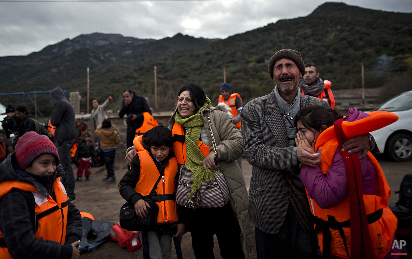  In this Thursday, Dec. 3, 2015 photo, Yazidi refugee Samir Qasu, 45, right, from Sinjar, Iraq, and his wife Bessi, 42, cry while embracing their children, Dunia, 13, and Dildar, 10, shortly after arriving on a vessel from the Turkish coast to the no