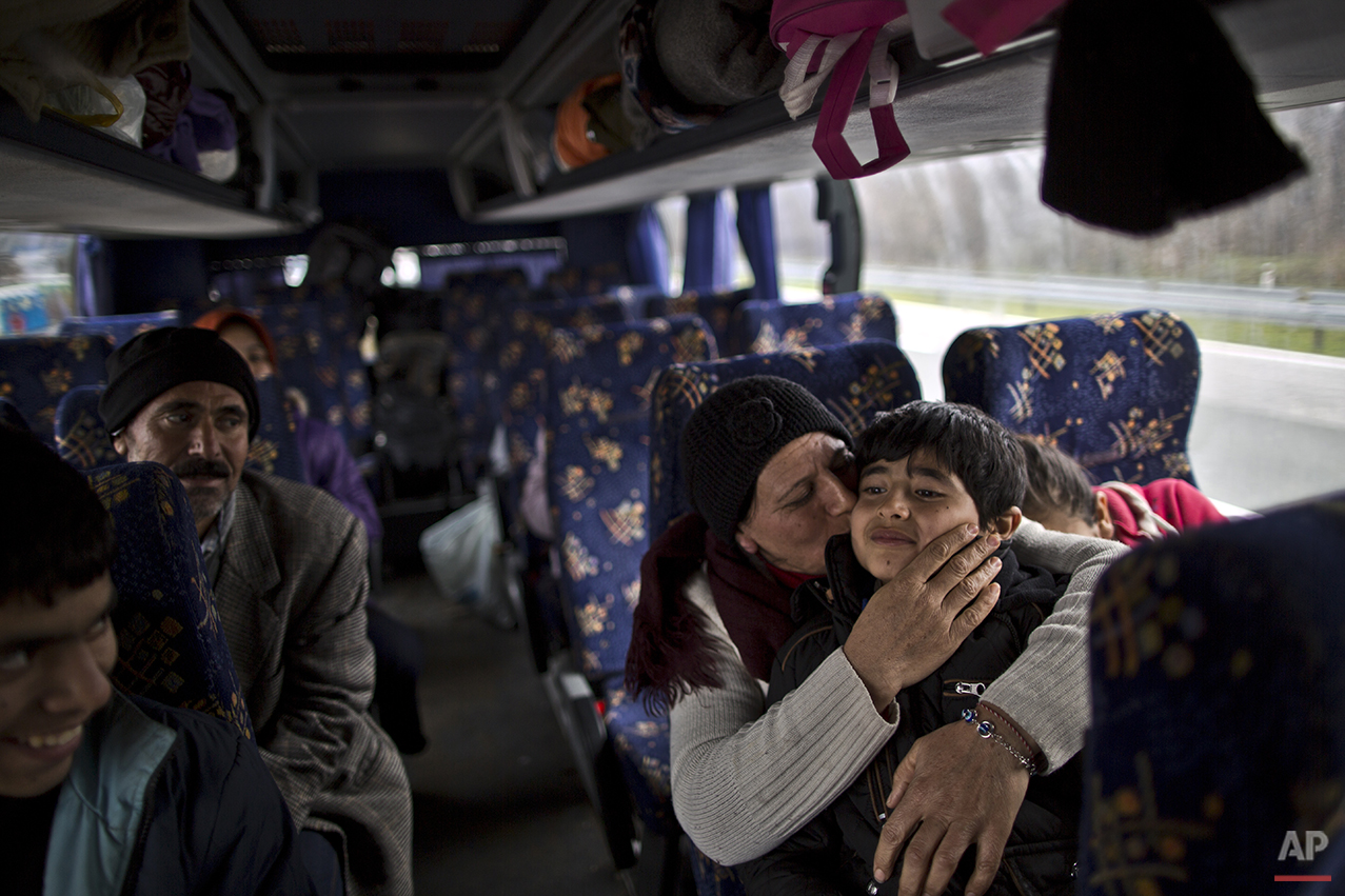  In this Sunday, Dec. 6, 2015 photo, Bessi Qasim, 42, a Yazidi refugee from Sinjar, Iraq, kisses her son Dildar, 10, as she and her family rest in a bus waiting to be transported to the train station in Sid where Serbian authorities load trains with 