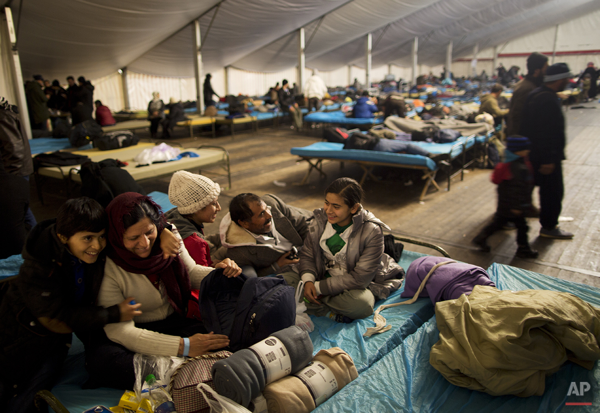  In this late Monday, Dec. 7, 2015 photo, the Qasu family, a Yazidi refugee family from Sinjar, Iraq, laugh with each other while resting on a bed in a shelter in Salzburg, Austria.  (AP Photo/Muhammed Muheisen) 