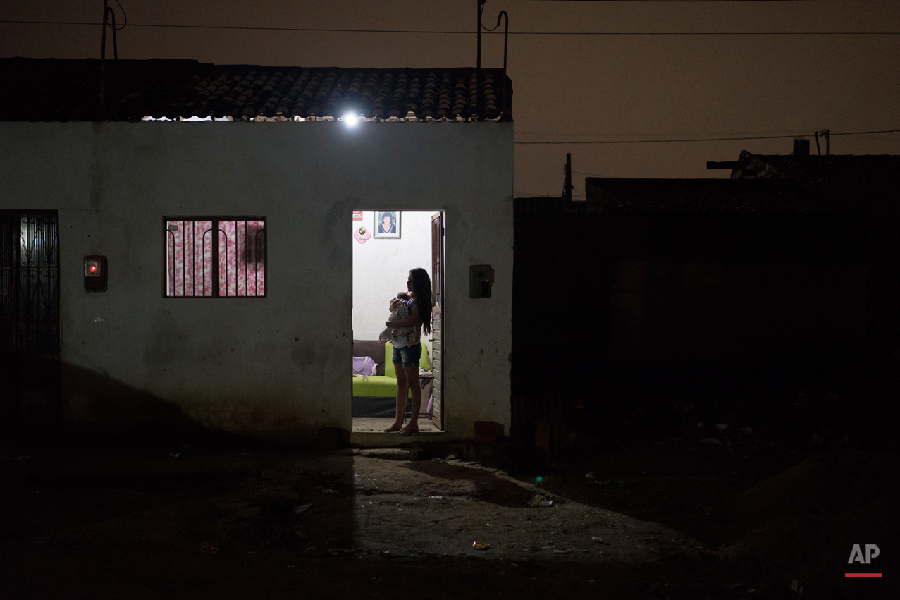  In this Dec. 22, 2015 photo, Angelica Pereira holds her daughter Luiza as she waits for her husband at their house in Santa Cruz do Capibaribe, Pernambuco state, Brazil. In the early weeks of Angelica Pereiraís pregnancy, a mosquito bite began bothe