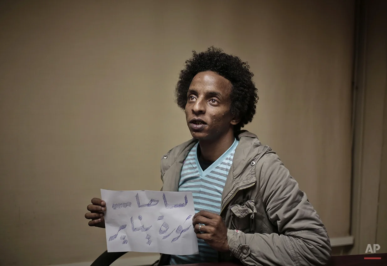 Hesham Abdel Hamid, a 25 year-old Egyptian photojournalist, poses for a photograph with a paper that reads, "it is still the January revolution," in his office, during the fifth anniversary of the 2011 uprising, in Cairo, Egypt, Monday, Jan. 25, 2016. "The 2011 uprising is special to my heart because this is when I met the love of my life. After five years the situation is much worse. Our voices are hidden. It is really difficult when you have principles and are requested to stand against them every day. The revolution was not supposed to be about one person, it was about uniting people behind an idea towards a higher purpose, and I do not see this happening at all," he says. Abdel Hamid went to Tahrir Square to hold up this sign but was not able to do it. (AP Photo/Nariman El-Mofty)