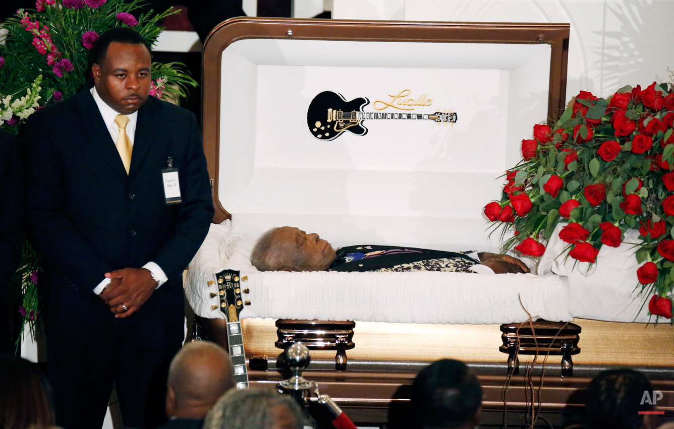 A funeral home attendant stands watch over the casket bearing blues legend ...