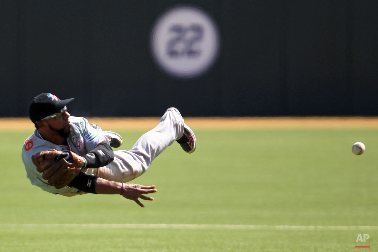 In this Feb. 4, 2015, photo, Dominican Republic outfielder Leury Garcia fields a ground ball and throws to first base during a Caribbean Series baseball game against Venezuela in San Juan, Puerto Rico. (AP Photo/Ricardo Arduengo)
