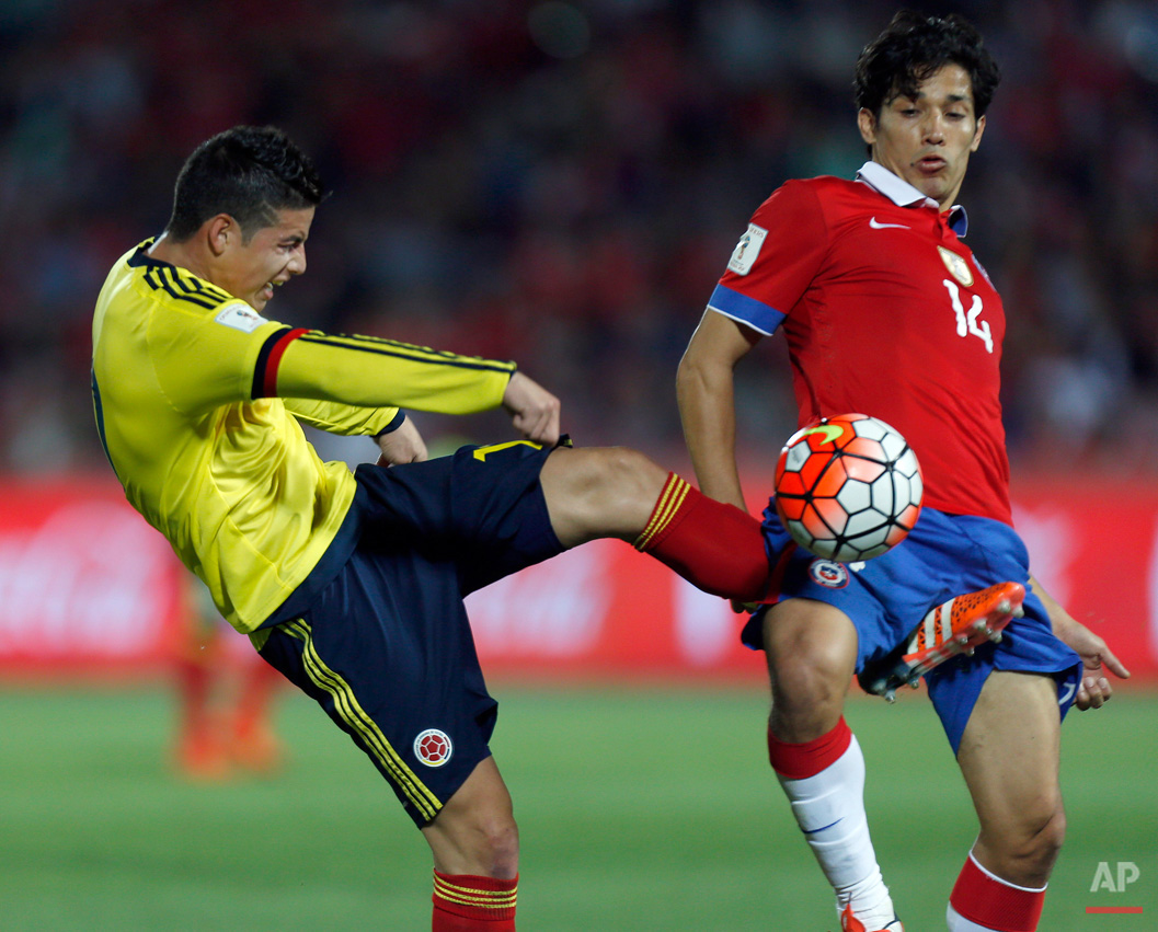 In this Nov. 12, 2015, photo, Colombia's James Rodriguez kicks Chile's Matias Fernandez as he tries to play the ball during a 2018 World Cup qualifying soccer match in Santiago, Chile, Thursday. (AP Photo/Luis Hidalgo)