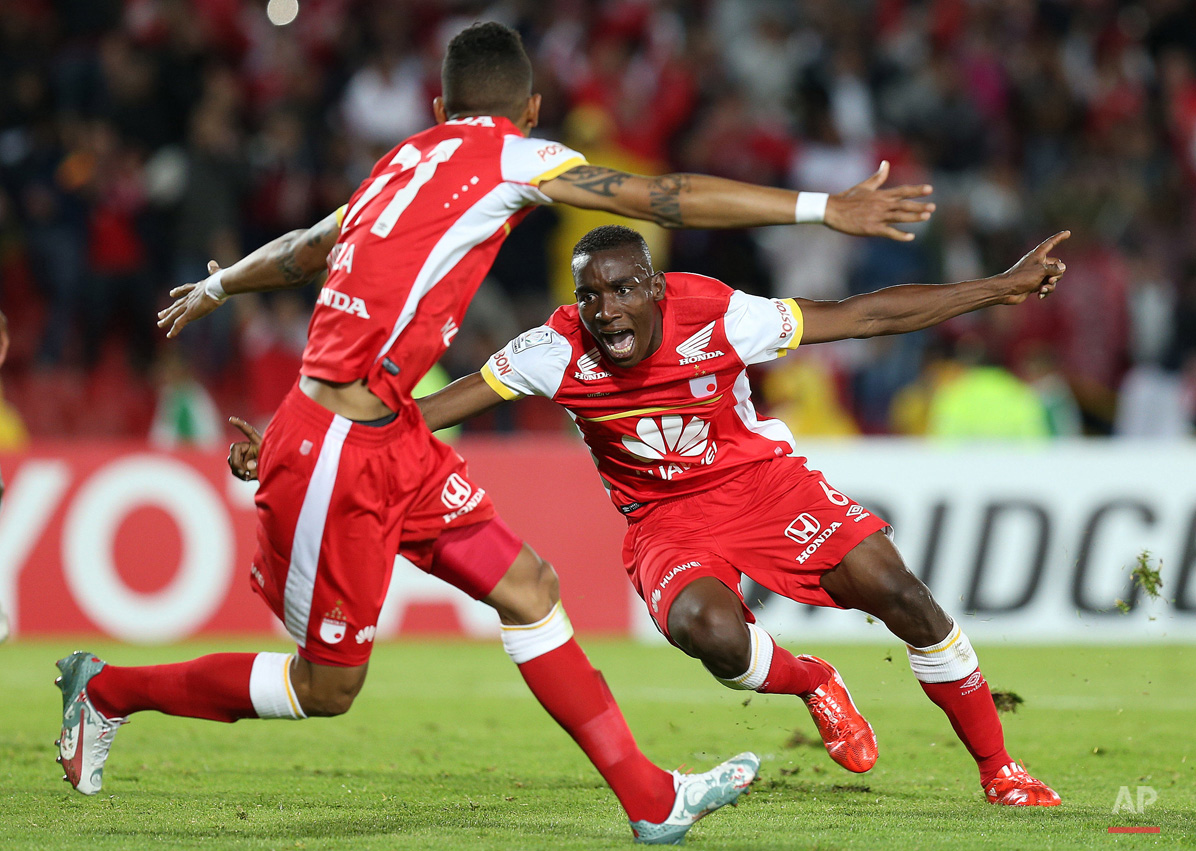 In this May 20, 2015, photo, Dairon Mosquera of Colombia's Independiente Santa Fe, right, celebrates scoring his side's first goal against Brazil's Internacional during a Copa Libertadores quarter finals first leg soccer match in Bogota, Colombia. (AP Photo/Fernando Vergara)