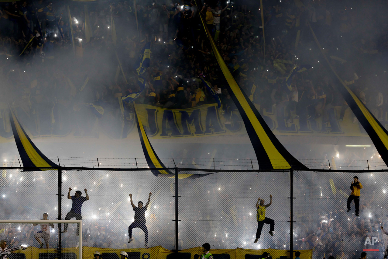 In this May 14, 2015, photo, Boca Juniors fans cheer their team before a Copa Libertadores round of sixteen soccer match against River Plate in Buenos Aires, Argentina. (AP Photo/Natacha Pisarenko)