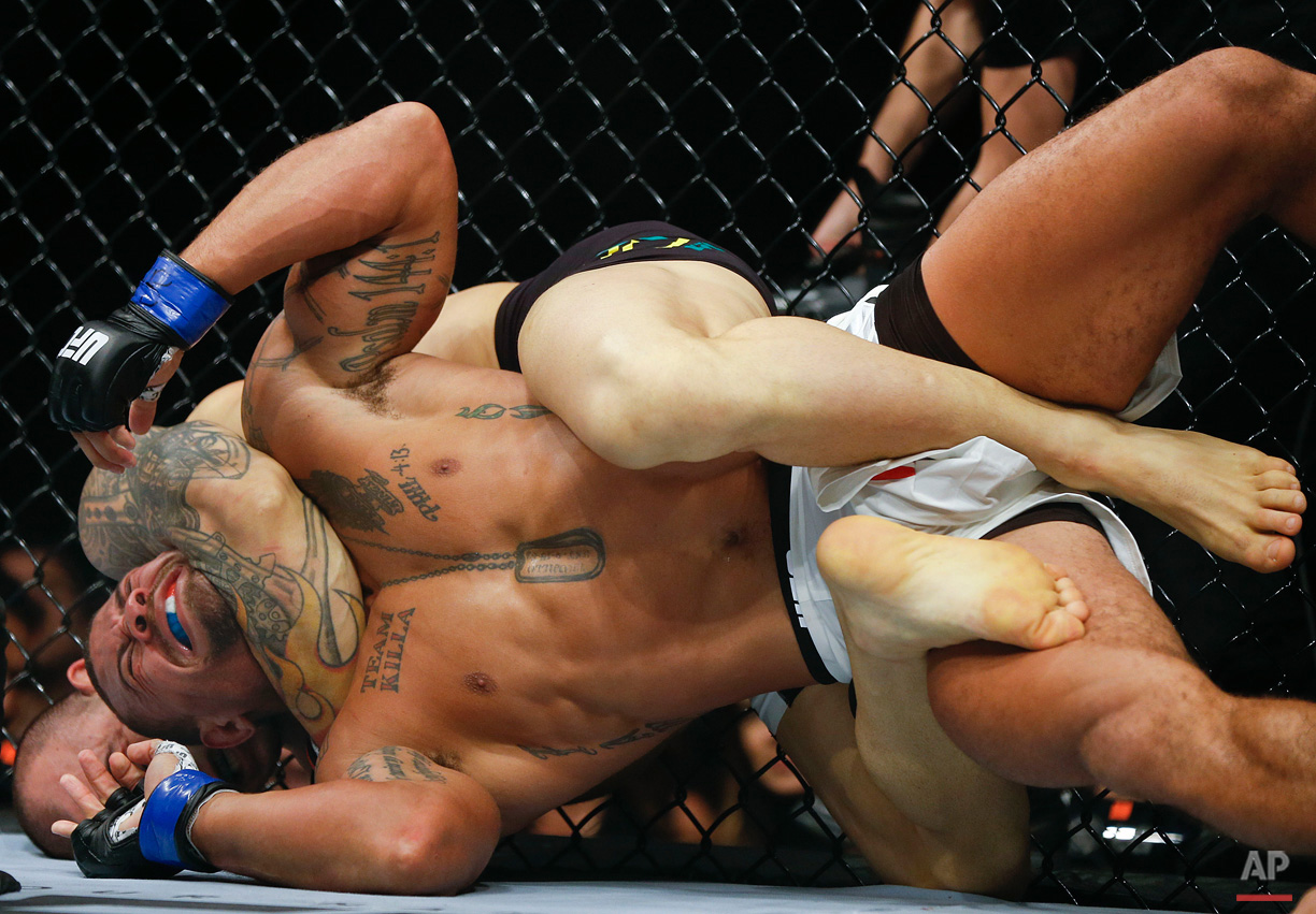 In this Nov. 8, 2015, photo, Gleison Tibau, from Brazil, back, chokes Abel Trujillo, from the United States, during their UFC lightweight mixed martial arts bout in Sao Paulo, Brazil. (AP Photo/Andre Penner)