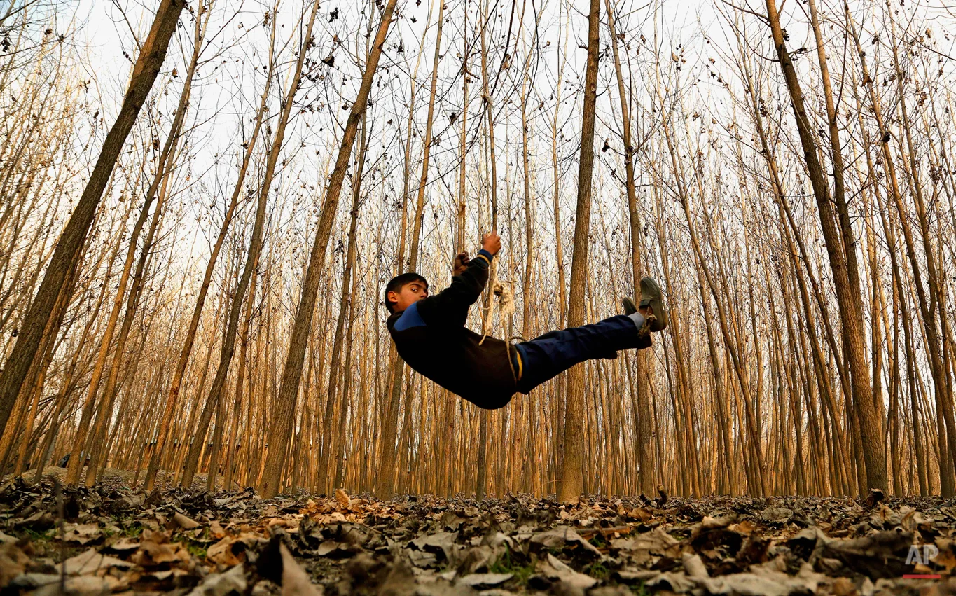 A Kashmiri boy plays on a swing in Srinagar, India, Thursday, Jan. 15, 2015. Set in the Himalayas at 5,600 feet above sea level, Kashmir is a green, saucer-shaped valley surrounded by snowy mountain ranges with over 100 lakes dotting its highlands and plains. (AP Photo/Mukhtar Khan)
