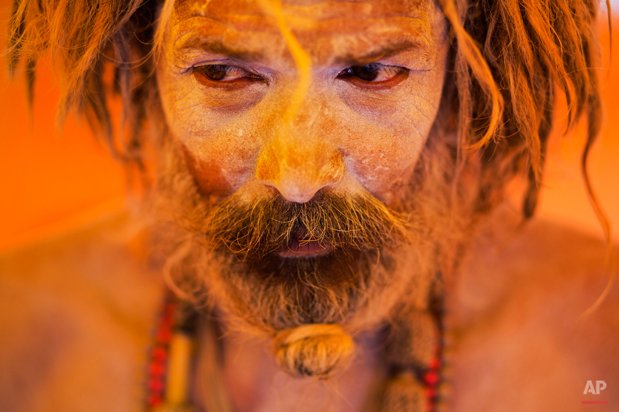  In this Aug. 27, 2015 photo, Naga sadhu, or naked Hindu holy man, pauses inside a tent during Kumbh Mela, or Pitcher festival, at Trimbakeshwar, India. Hindus believe taking a dip in the waters of a holy river during the festival will cleanse them o
