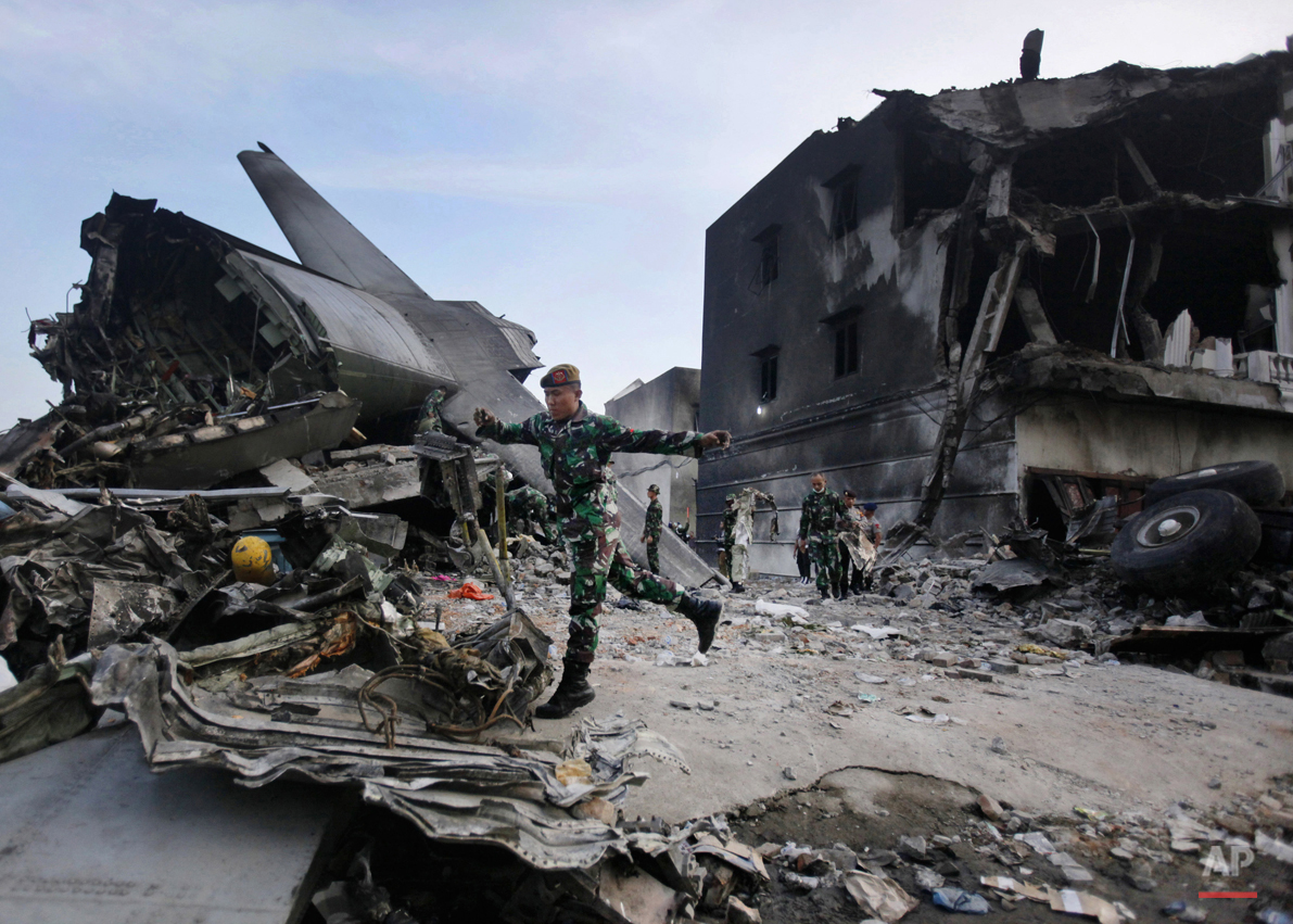  Rescuers search for victims at the site where an Indonesian air force transport plane crashed in Medan, North Sumatra, Indonesia, Wednesday, July 1, 2015. The C-130 Hercules plane crashed into a residential neighborhood in the country's third-larges