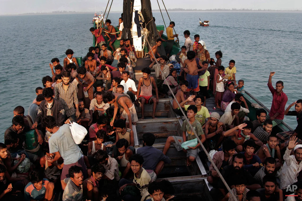 In this Wednesday, May 20, 2015, photo, migrants wait to be be rescued by Acehnese fishermen on their boat on the sea off East Aceh, Indonesia. Many of the thousands of migrants abandoned at sea in Southeast Asia this month are Rohingya Muslims who fled their home country of Myanmar. The Rohingya are a Muslim minority in predominantly Buddhist Myanmar, also known as Burma. Numbering around 1.3 million, they are concentrated in western Rakhine state, which neighbors Bangladesh. (AP Photo/S. Yulinnas)