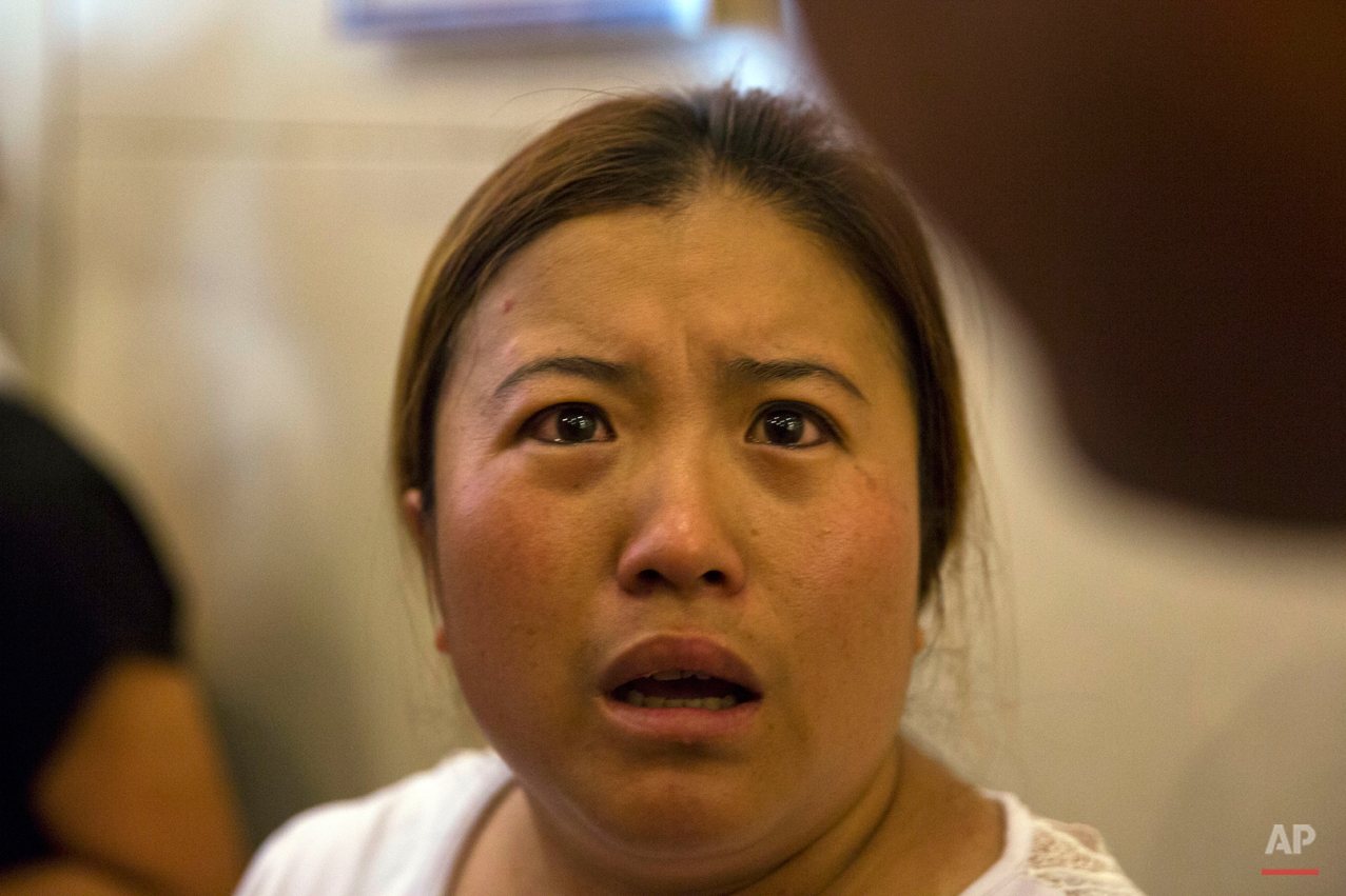  In this Saturday, Aug. 15, 2015 photo, Wang Baoxia talks to journalists about her missing brother Wang Quan who was at the scene of an explosion in northeastern China's Tianjin municipality. Angry family members of firefighters missing in the explos