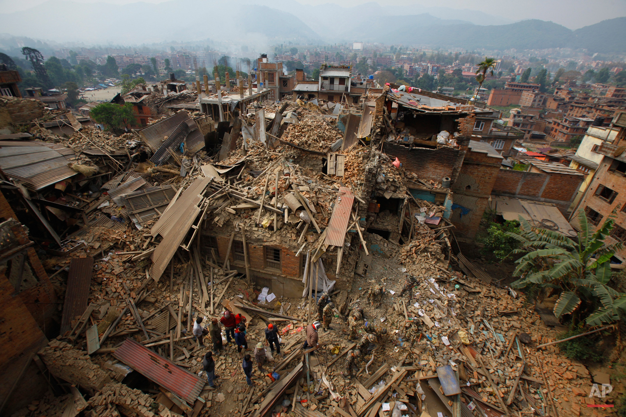  In this Sunday, April 26, 2015, photo, rescue workers remove debris as they search for victims of an earthquake in Bhaktapur near Kathmandu, Nepal. A strong magnitude earthquake shook Nepal's capital and the densely populated Kathmandu Valley before