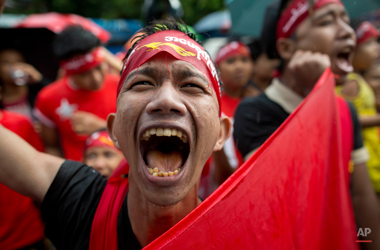  In this Monday, Nov. 9, 2015, photo, a supporter of Myanmar's National League for Democracy party braves rain outside the NLD headquarters in Yangon, Myanmar. Opposition leader Aung San Suu Kyi's NLD party was confident Monday that it was headed for