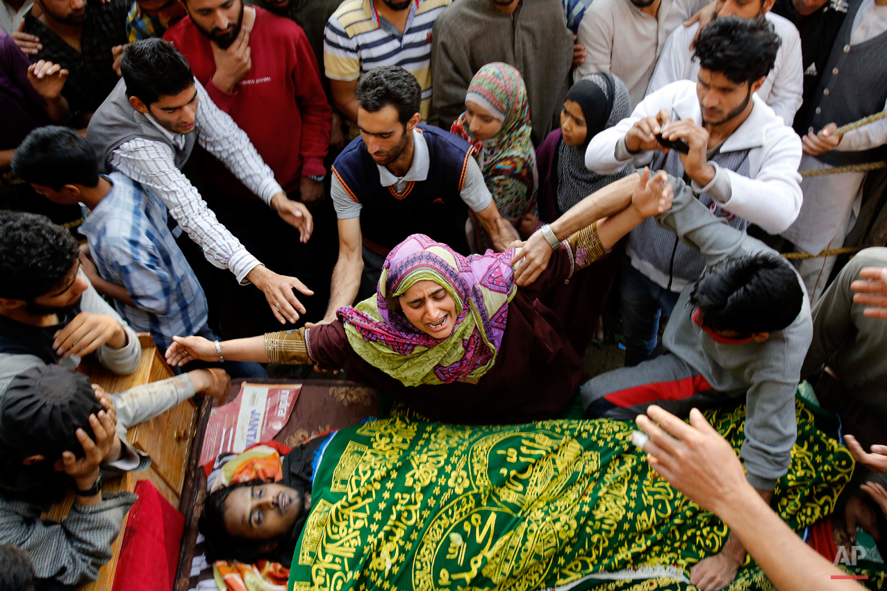  In this Oct. 5, 2015 photo, a Kashmiri Muslim woman wails near the body of a suspected rebel, during his funeral at Barhama, 40 kilometers (25 miles) south of Srinagar, Indian controlled Kashmir, Monday, Oct. 5, 2015. At least four Indian army soldi