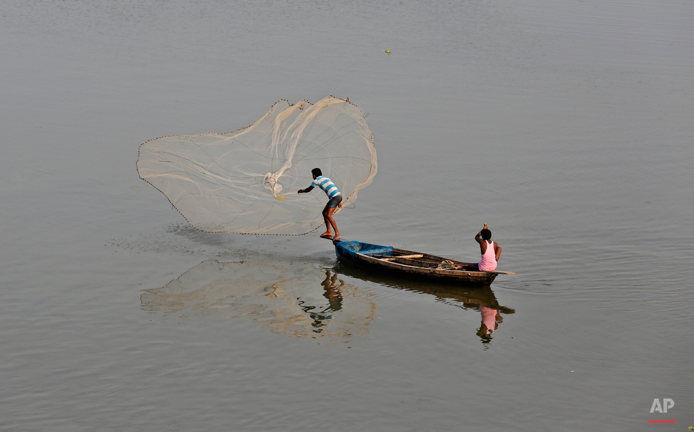  In this Aug. 7, 2015 photo, an Indian fisherman throws a fishing net into the Gomti River in Lucknow, India. It is considered auspicious to take a dip in the waters of the River Gomti so as to rid away the sins, as per the Hindu mythology. (AP Photo