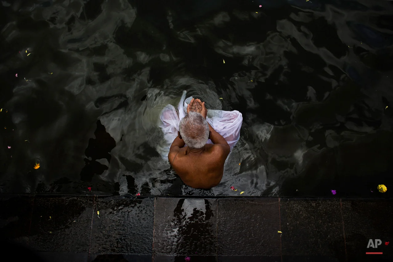 In this Wednesday, Aug. 26, 2015, photo, a Hindu devotee performs a holy dip in the Godavari River during Kumbh Mela, or Pitcher Festival, in Nasik, India. Millions of Hindus are expected to immerse themselves in the Godavari River as a way to cleanse themselves of sin and come closer to God at this year's Kumbh Mela festival. (AP Photo/Bernat Armangue)