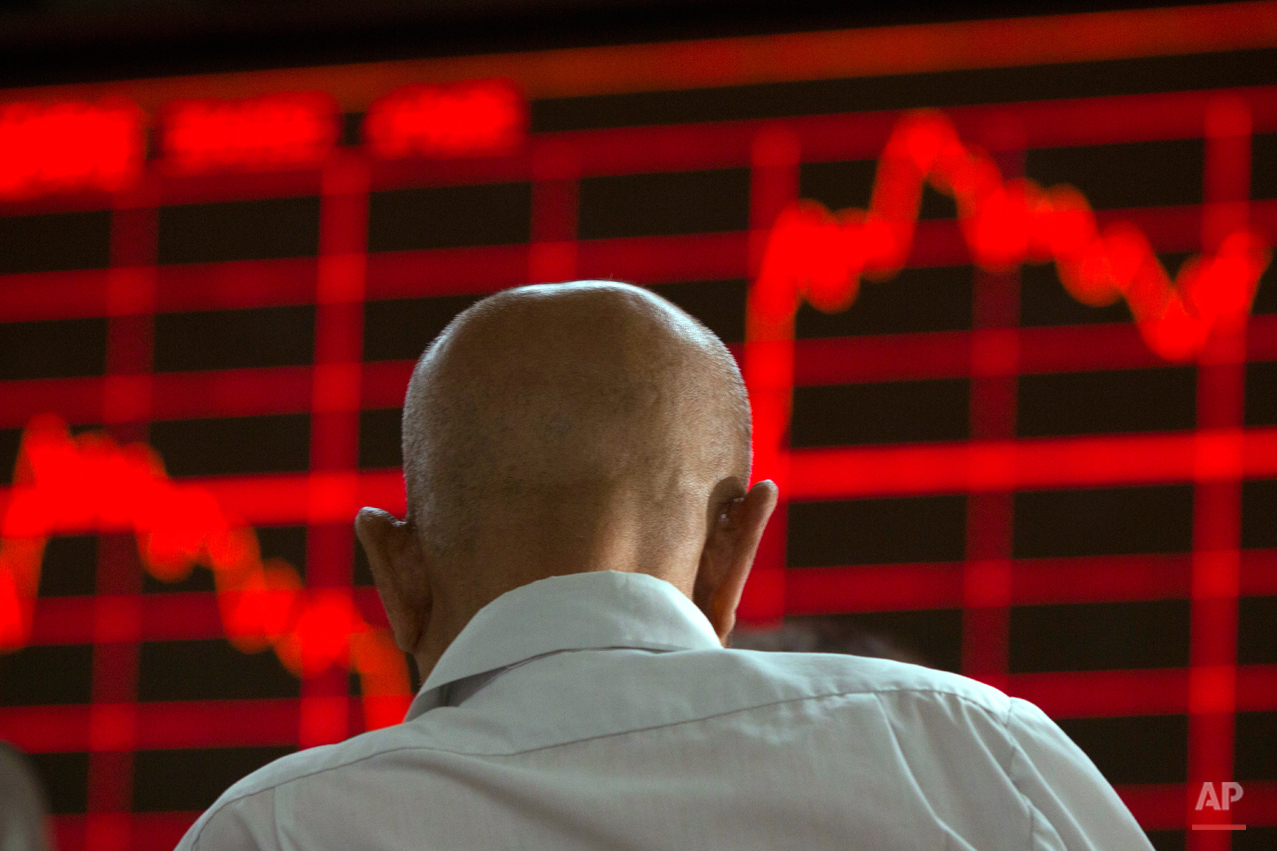  In this Aug. 26, 2015, photo, a Chinese investor monitors stock prices at a brokerage in Beijing. Asian stocks were mixed Wednesday and Shanghai's index fell despite Beijing's decision to cut a key interest rate to help stabilize gyrating financial 