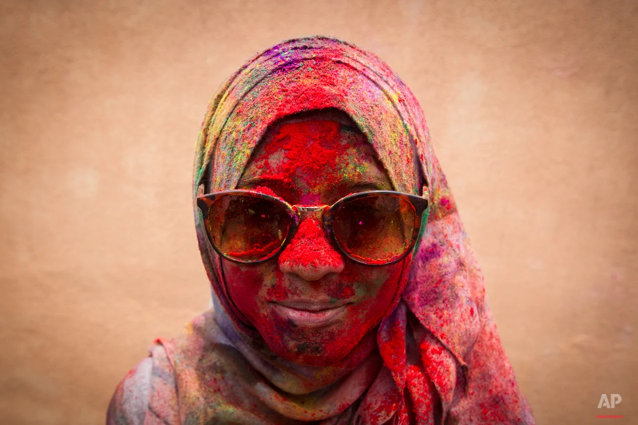 In this Saturday, March 21, 2015, photo, a Malaysian Muslim woman poses for a photo during the religious spring festival Holi in Kuala Lumpur, Malaysia. Holi, the Hindu festival of colors, is celebrated by people throwing colored powder and water at each other. (AP Photo/Joshua Paul)