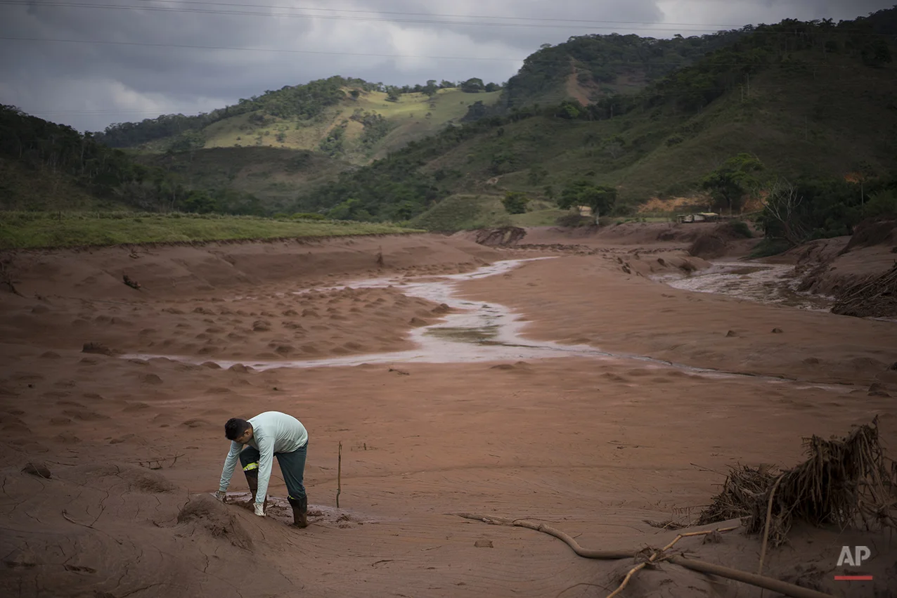  An electricity worker attempts to cross a flooded area in Barra Longa after a dam burst on Thursday in Minas Gerais state, Brazil, Saturday, Nov. 7, 2015. (AP Photo/Felipe Dana) 