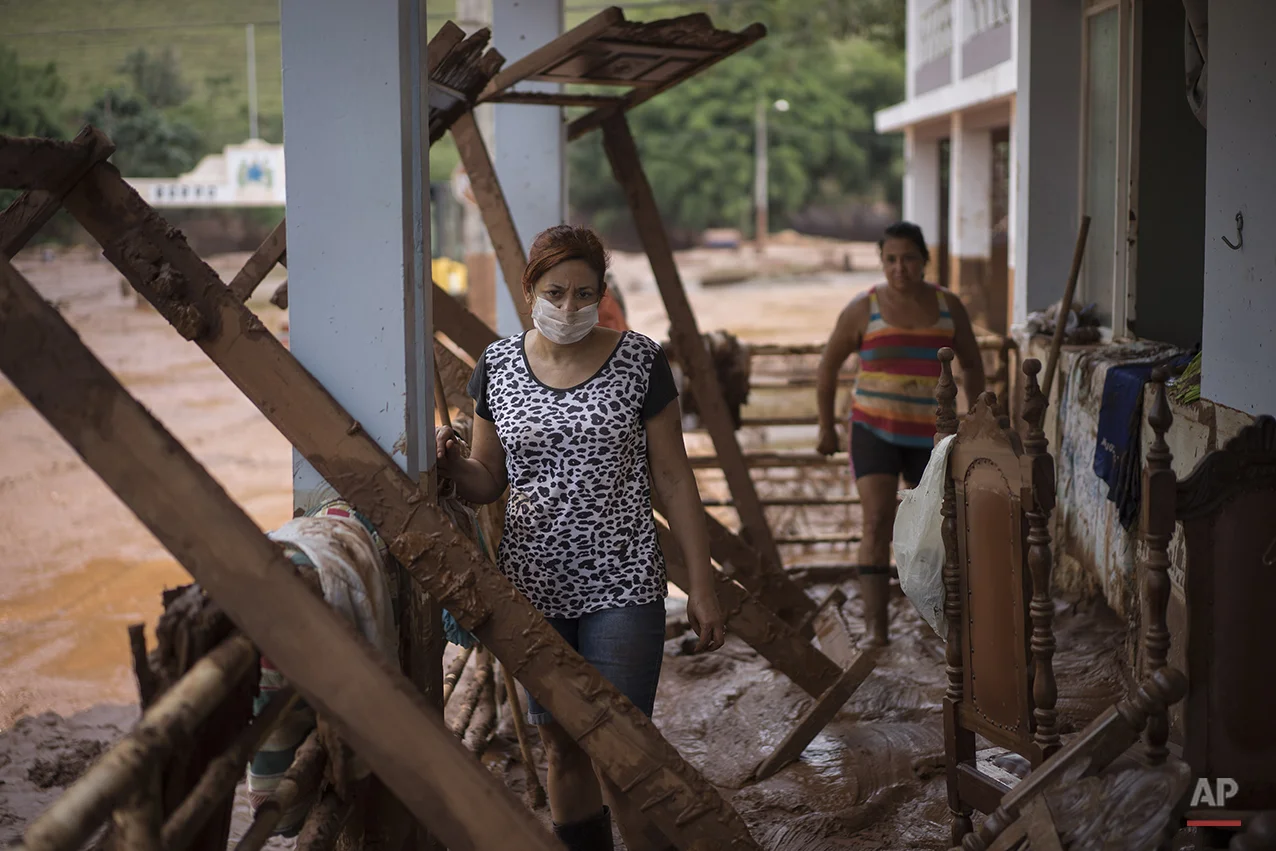  People stand in their damaged home in Barra Longa after a dam burst on Thursday in Minas Gerais state, Brazil, Saturday, Nov. 7, 2015. (AP Photo/Felipe Dana) 