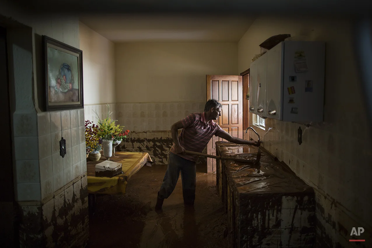  Antonio Carlos Carneiro removes mud from his damaged home in Barra Longa after a dam burst on Thursday in Minas Gerais state, Brazil, Saturday, Nov. 7, 2015.&nbsp;(AP Photo/Felipe Dana) 