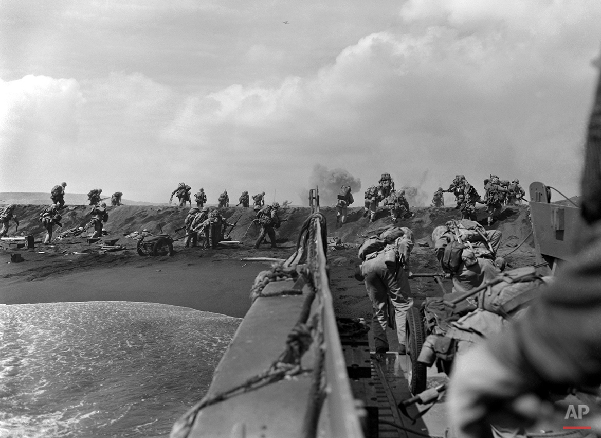  In the Pacific theater of World War II, U.S. Marines hit the beach and charge over a dune on Iwo Jima in the Volcano Islands Feb. 19, 1945, the start of one of the deadliest battles of the war against Japan. (AP Photo/Joe Rosenthal) 