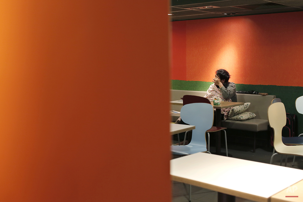  In this Nov. 9, 2015 photo, a man sits with his belongings at night in a 24-hour McDonald’s branch in Hong Kong. The recent death of a woman at a Hong Kong McDonald’s, where her body lay slumped at a table for hours unnoticed by other diners, has fo