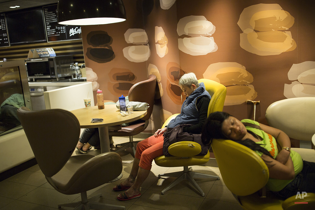  In this Oct. 29, 2015 photo, a group of people sleep at night in a 24-hour McDonald’s branch in Hong Kong. The recent death of a woman at a Hong Kong McDonald’s, where her body lay slumped at a table for hours unnoticed by other diners, has focused 