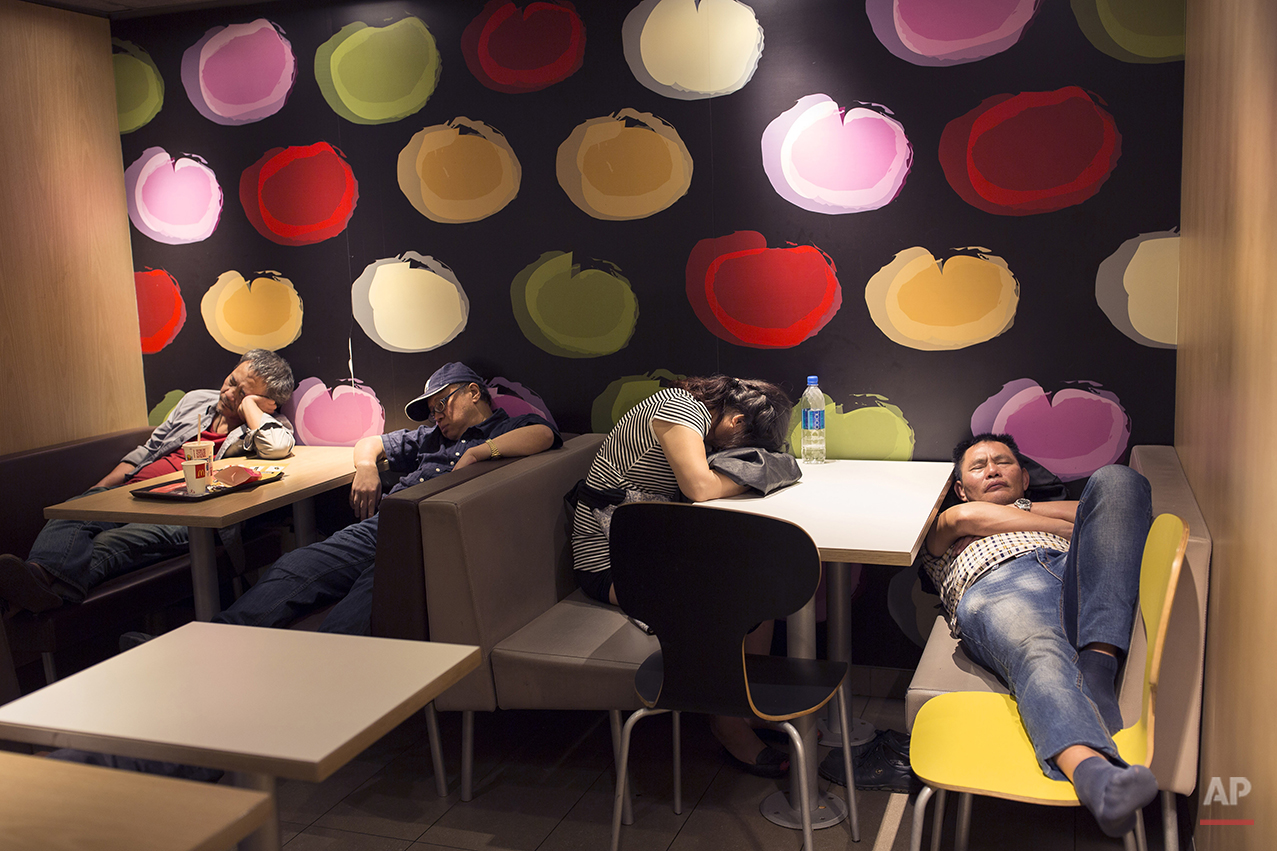  In this Oct. 30, 2015 photo, a group of people sleep at night in a 24-hour McDonald’s branch in Hong Kong. The recent death of a woman at a Hong Kong McDonald’s, where her body lay slumped at a table for hours unnoticed by other diners, has focused 