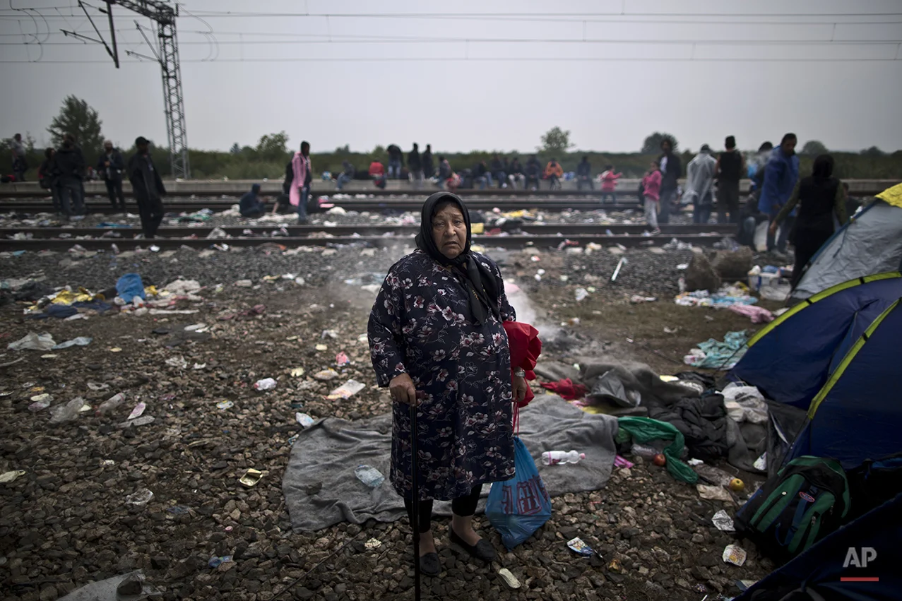 In this photo taken on Sunday, Sept. 20, 2015, Afghan refugee Bibi Gul Ali, who came from Herat, Afghanistan, poses for a picture while hoping to board a train at the station in Tovarnik, Croatia. "I am a widow, I am alone I don't know where I am going,” she said. (AP Photo/Muhammed Muheisen)