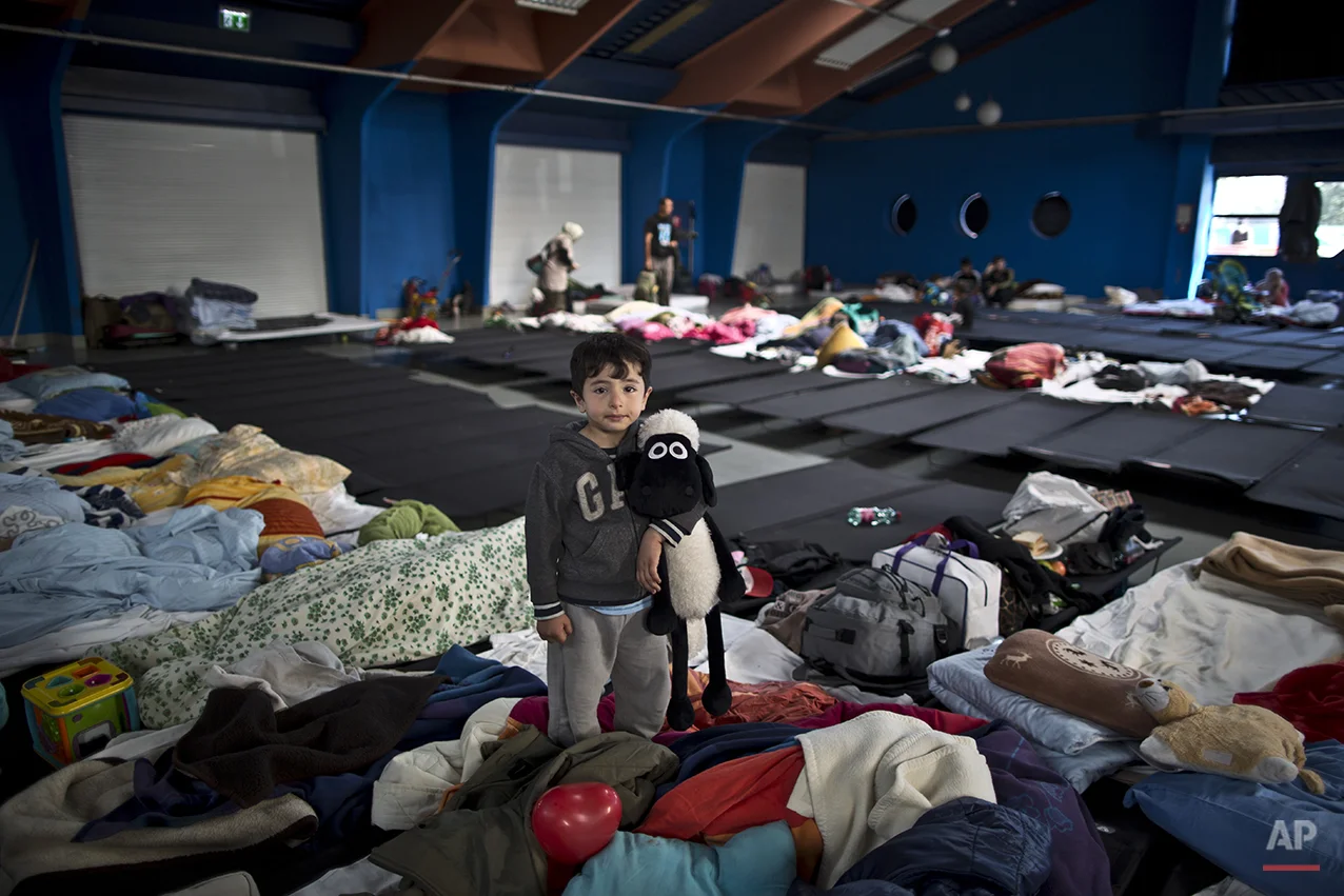 In this photo taken on Tuesday, Sept. 22, 2015, Syrian refugee Osama Bakir, 5, who came with his parents from Aleppo, Syria, holds his toy while posing for a picture in a shelter near Graz, Austria. "We are going to Germany," he said. (AP Photo/Muhammed Muheisen)