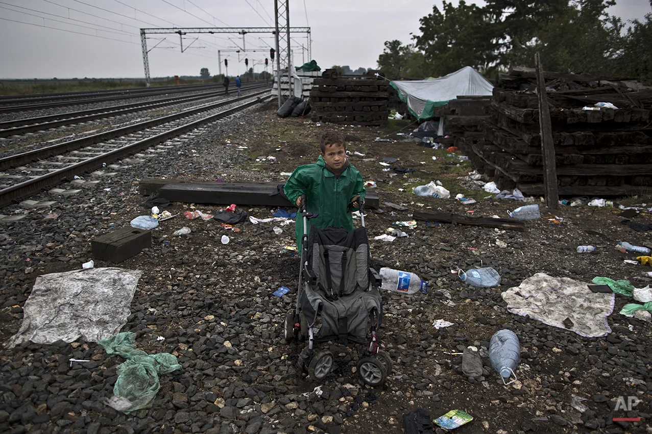 In this photo taken on Sunday, Sept. 20, 2015, Syrian refugee Radwan Shtaiwi, 8, who came from Deir el-Zour, Syria, poses for a picture while he and his family are hoping to board a train at the station in Tovarnik, Croatia. "I wish to go to Germany to see my father who had been there for a year, I just want to be with my dad again and my mother is a teacher and I wish she will find work and go to the same school with her," he said. (AP Photo/Muhammed Muheisen)