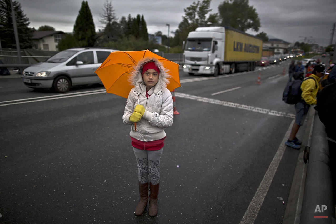 In this photo taken on Thursday, Sept. 24, 2015, Afghan refugee Fatima Rezai, 10, who came with her parents from Mazar-i Sharif, Afghanistan, poses for a picture while waiting on a bridge after spending the night waiting for their registration and transport by German police to a refugee shelter in Freilassing, Germany. "Life in Afghanistan is so scary especially for girls, I was so afraid in this trip was so difficult and long walking, I am hoping to become a doctor in Germany and help people,” she said. (AP Photo/Muhammed Muheisen)