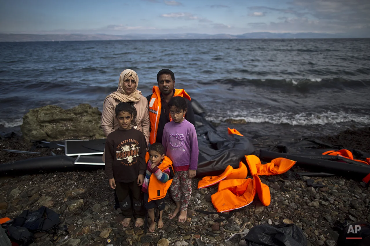 In this photo taken on Thursday, Oct. 1, 2015, Iraqi refugee Mohammed Sadoun, 39, and his wife Suhad, 35, who came from Mosul, Iraq, pose for a picture with their children from right, Abdulrahman, 9, Abdullah, 3, and Hadeel, 11, shortly after arriving on a dinghy from the Turkish coast to the northeastern Greek island of Lesbos. “We had to run from Islamic State, IS, death will reach us all if we don’t. I wish to reach Germany where humanity exists, and my children will grow up with a bright future,” Mohammed Sadoun said. (AP Photo/Muhammed Muheisen)