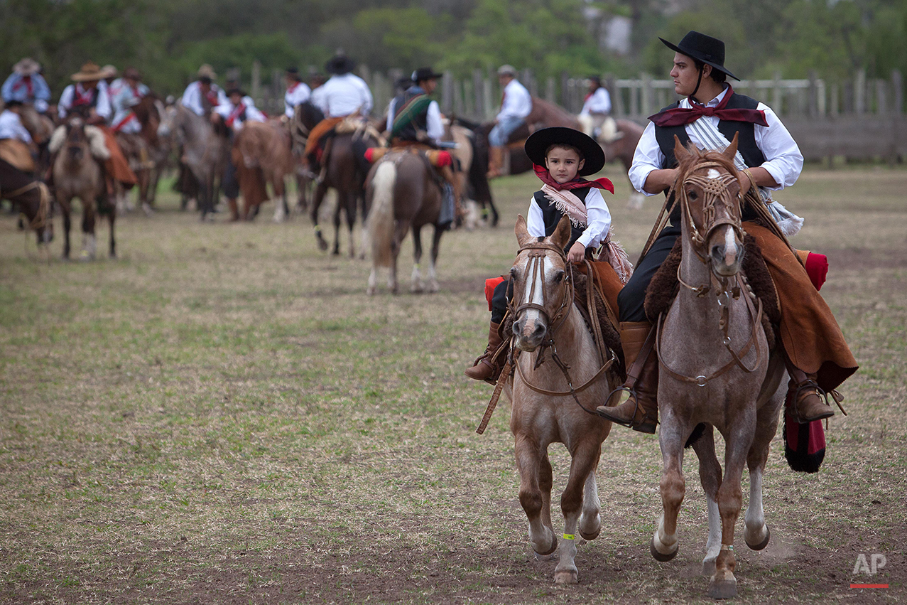  In this Sept. 20, 2015 photo, a boy and his father prepare to participate in the parade of Semana Farroupilha or “Ragamuffin” week, in Alegrete municipality, Rio Grande do Sul state, Brazil. Each September, the locals keep their cowboy cultural aliv