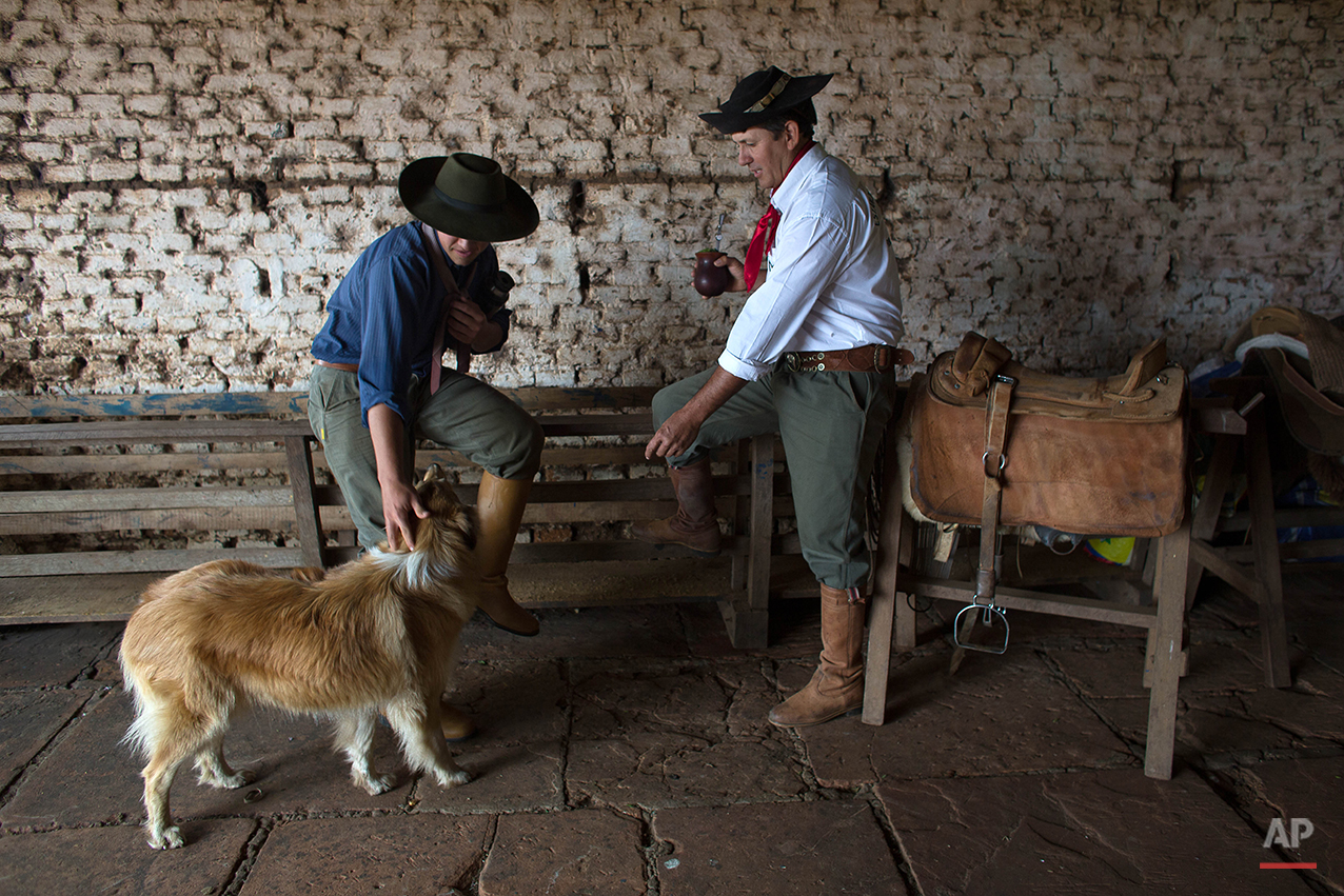  In this Sept. 18, 2015, gauchos Luiz Guilherme de Oliveira, 15, left, and Antonio Carlos Pereira, 45, drink mate in Santa Izabel estancia, Alegrete municipality, Rio Grande do Sul state, Brazil. Mate is a traditional South American infused drink, it