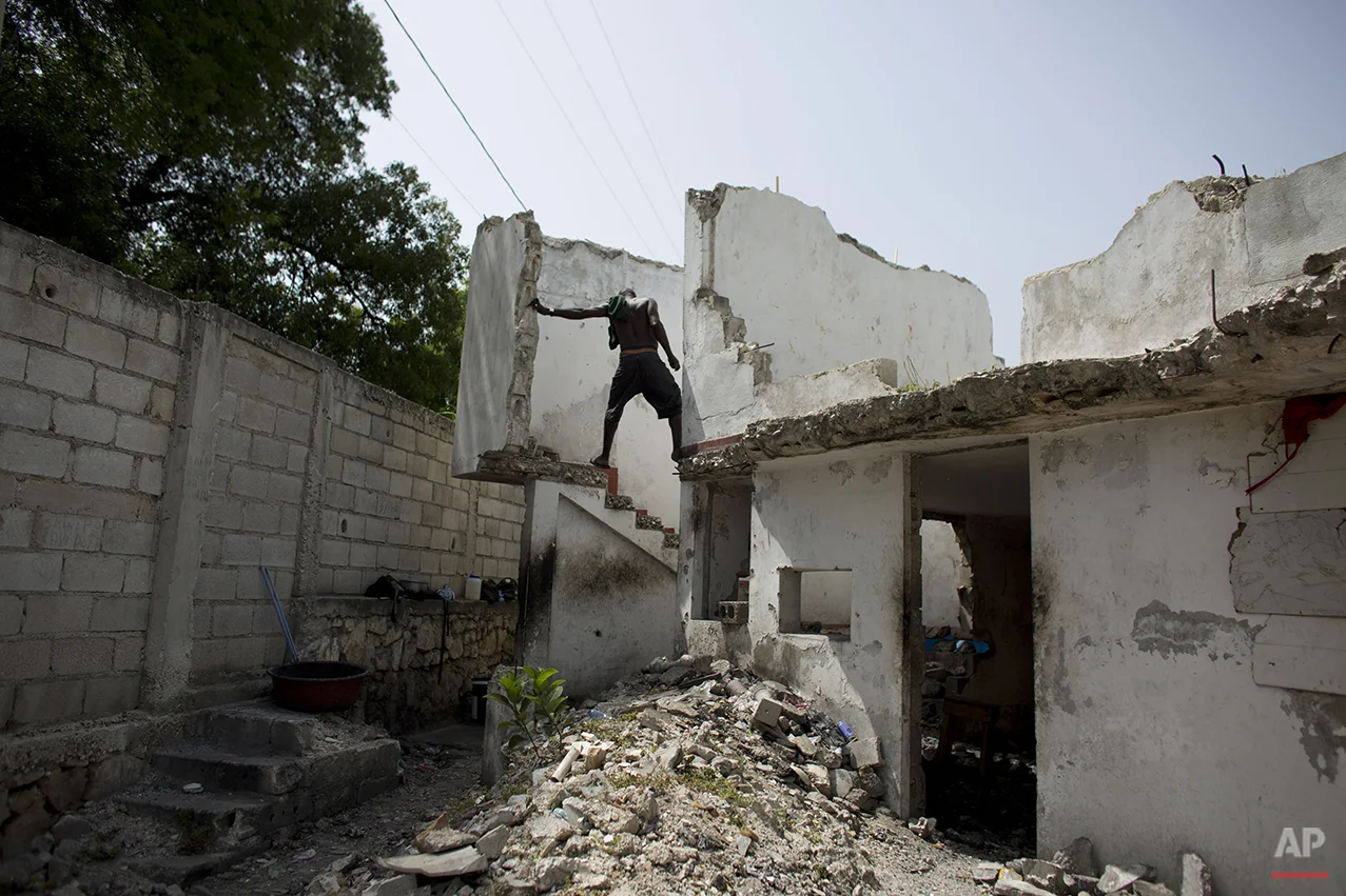  In this June 29, 2015 photo, a resident of the earthquake-damaged Hotel Le Palace makes his way downstairs from the room he inhabits in central Port-au-Prince, Haiti. Though much of the hotel was destroyed, some of the guest rooms, which still have 