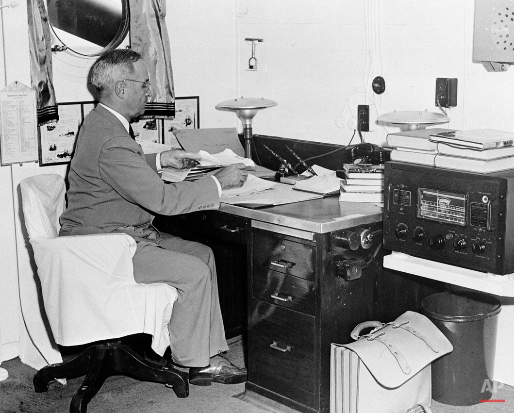  In this Aug. 6, 1945, photo, aboard the cruiser Augusta, President Harry S. Truman, with a radio at hand, reads reports of the first atomic bomb raid on Japan, while en route home from the Potsdam conference. On two days in August 1945, U.S. planes 